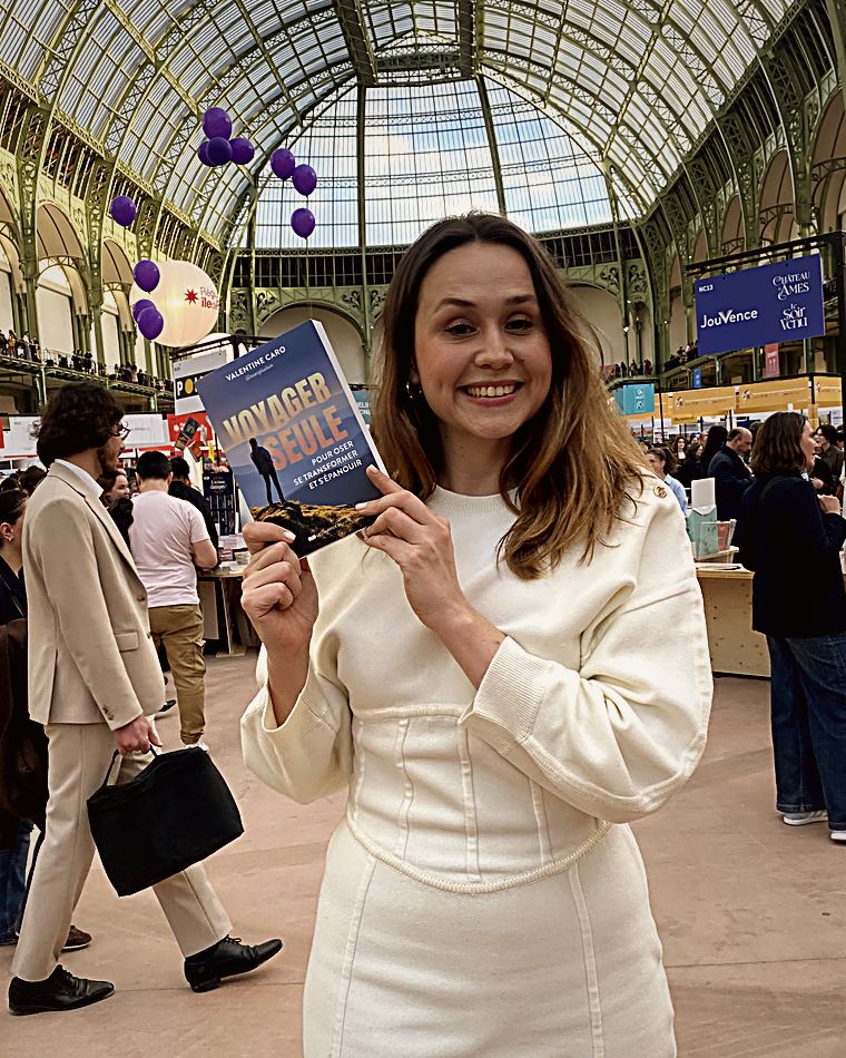 Valentine au Grand Palais, tenant son livre « Voyager seule »